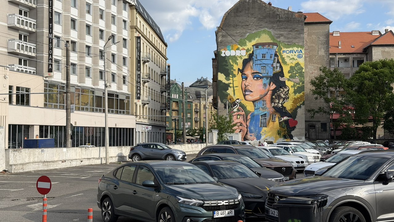 Colorful street art mural of a woman's face painted on an urban building facade in Bucharest, illustrating street art's influence on contemporary creative design.