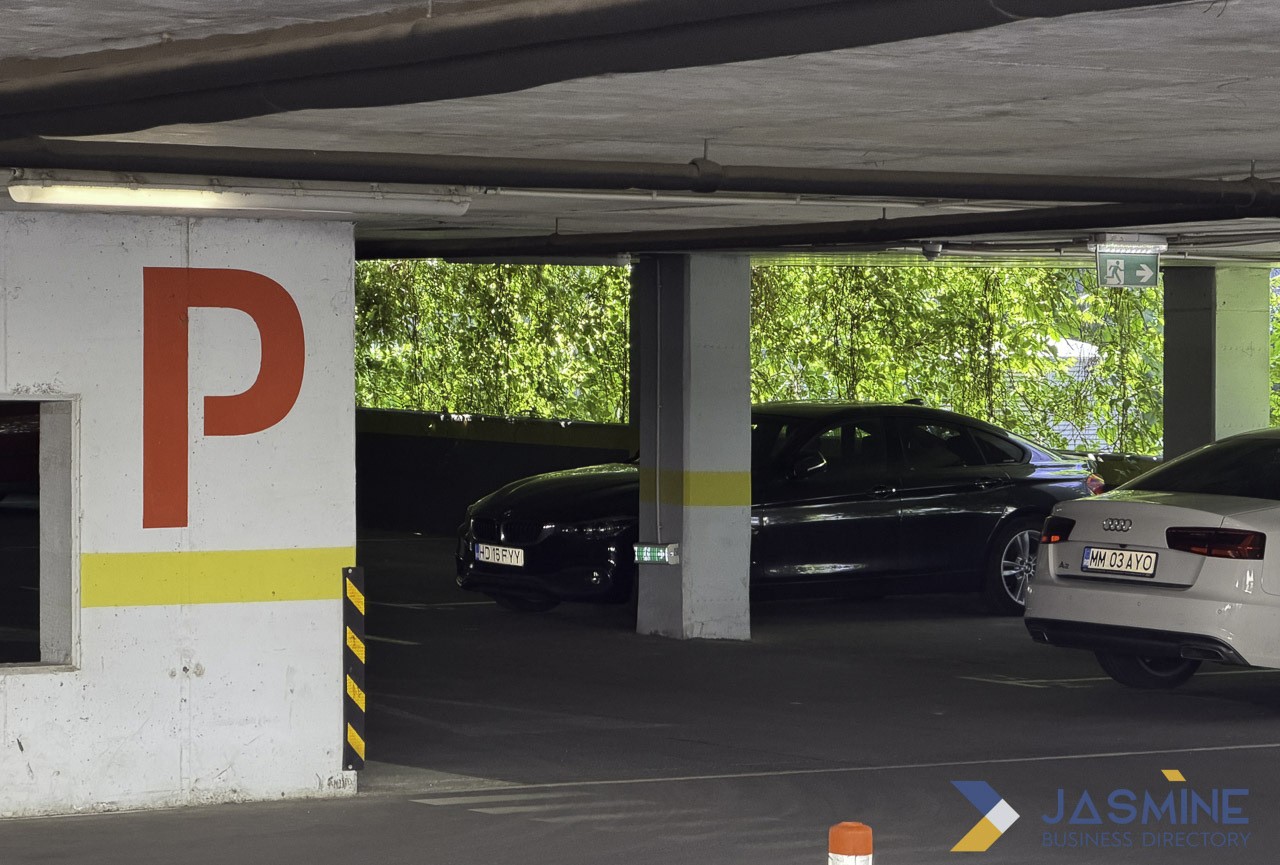 Underground parking garage interior with concrete pillars, red signage, and living green wall, illustrating professional photography for enriching business directory listings.
