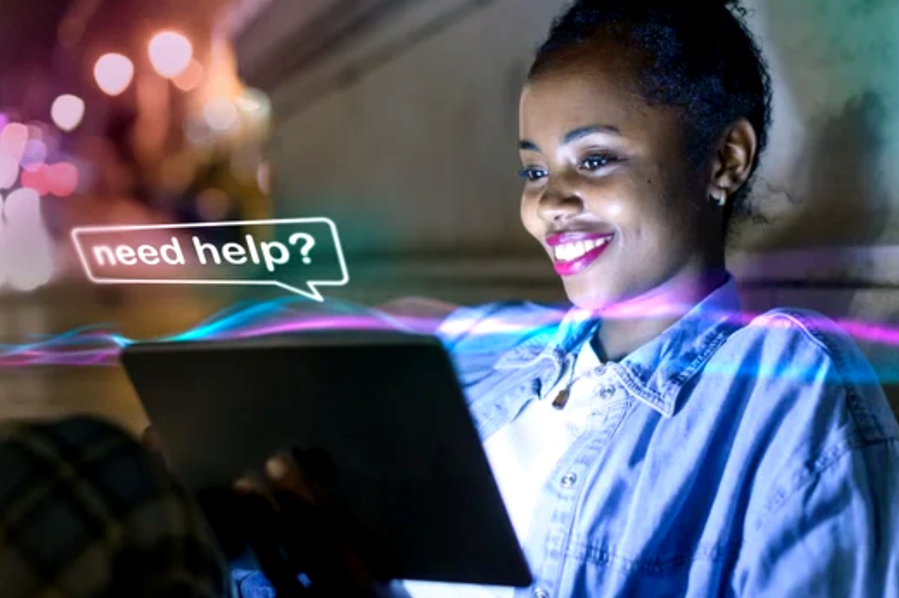 Woman holding tablet with 'need help?' chat bubble overlay, illuminated by colorful lighting, representing AI chatbot customer support solutions for small businesses.